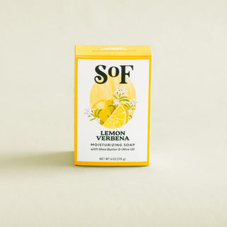 A yellow and white box of Lemon Verbena Moisturizing Bar Soap, enriched with organic shea butter and featuring lemon and verbena illustrations, is displayed against a light background.