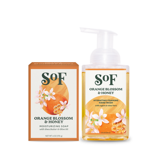 A box of Orange Blossom & Honey Bar Soap sits beside a pump bottle of Orange Blossom & Honey Foaming Hand Soap, both adorned with orange blossom and honeycomb designs for a daily cleanse infused with beautifully layered scents.