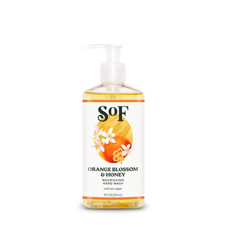 A bottle of Orange Blossom & Honey Nourishing Hand Wash (8 fl oz) with pump dispenser features a label with orange slices and white flowers, is paraben-free, contains sea algae, and comes in an 8 fl oz (236 ml) size.