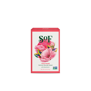 A rectangular box labeled “Wild Rose Moisturizing Bar Soap” displays pink flowers, green leaves, natural colorants, and a “Non-GMO Project Verified” logo on its packaging.